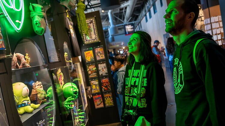A wide shot of people viewing exhibit displays in a museum