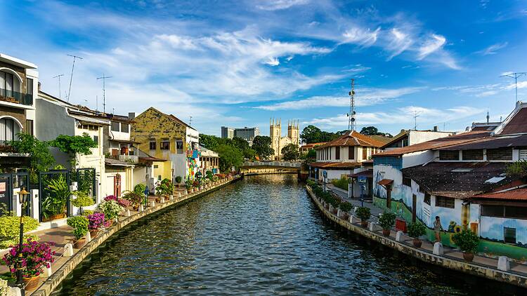Malacca, Malaysia A river running through a city next to tall buildings