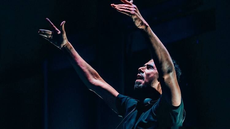 A close-up of a performer raising his hands on a stage. A close-up of a performer raising his hands on a stage.