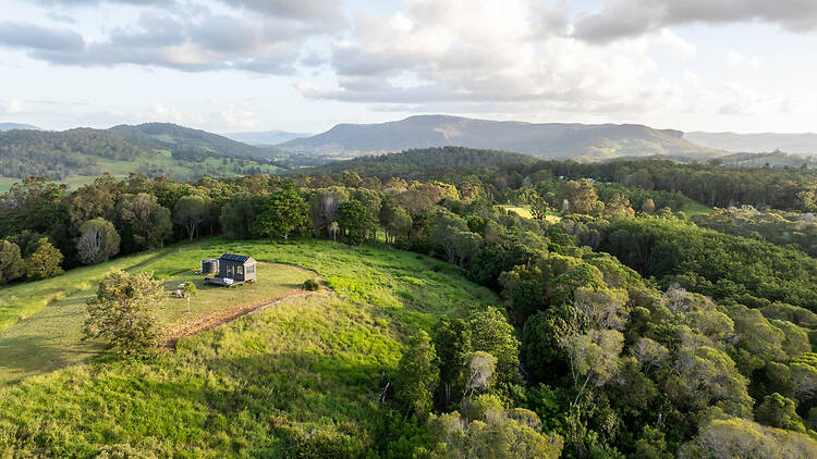 Into The Wild Escapes Tiny home on green hill