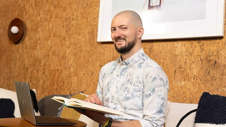 A close-up of a person reading from a book at a queer storytelling event.