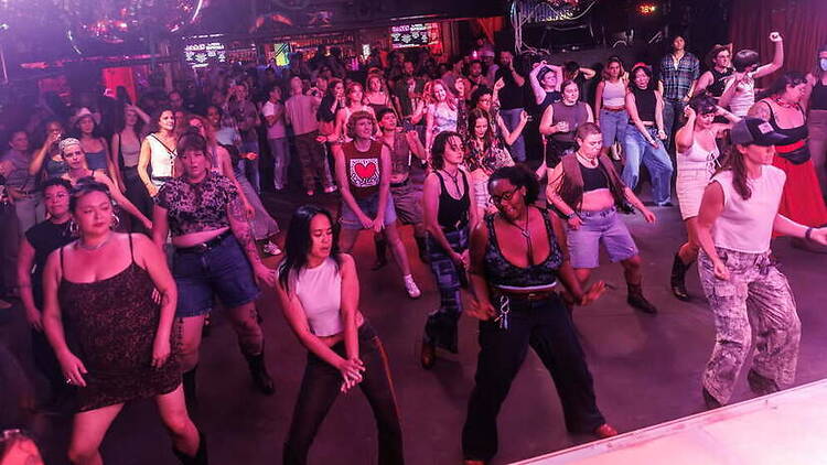 A wide shot of people dancing in a nightclub.