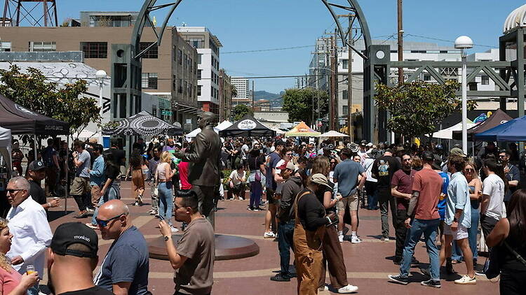 A wide shot of people walking through an outdoor festival.