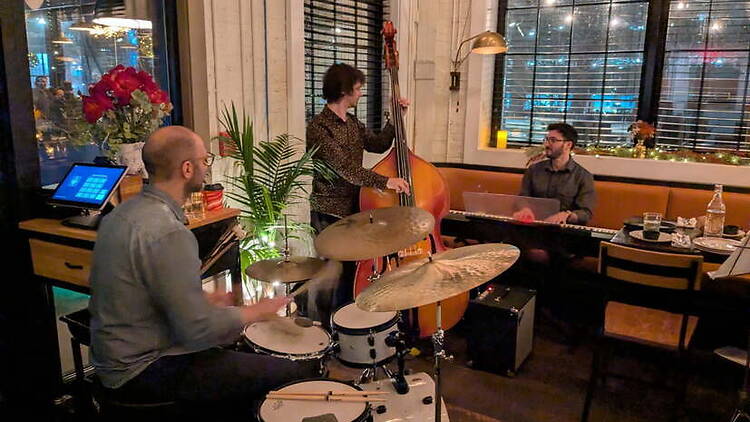 A trio of musicians performing in a restaurant.