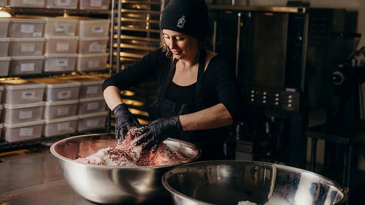 A close-up of a baker mixing ingredients in a commercial kitchen