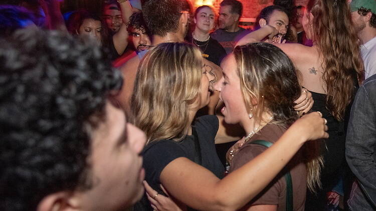 A wide shot of people dancing together in a crowded nightclub. A wide shot of people dancing together in a crowded nightclub.