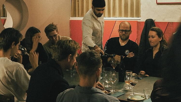 A wide shot of diners sharing a meal in a restaurant. A wide shot of diners sharing a meal in a restaurant.