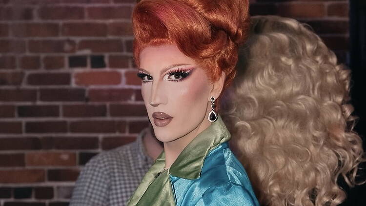 Close-up of a person posing against a brick wall.