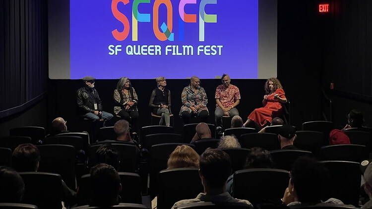 A wide shot of panelists speaking to an audience in a movie theater A wide shot of panelists speaking to an audience in a movie theater