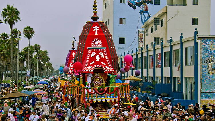 A wide shot of people gathering around a colorful parade float on a busy street