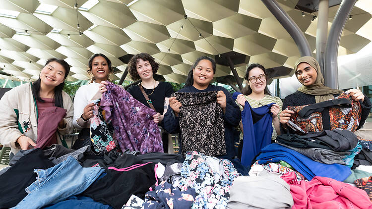 Zero Waste Festival Women hold up clothing they have repaired and fixed for reuse.