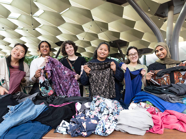 Zero Waste Festival Women hold up clothing they have repaired and fixed for reuse.