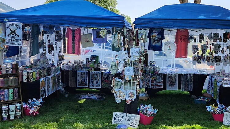 A wide shot of a vendor booth displaying handmade goods at an outdoor market