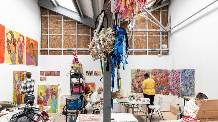Artists working in the studio with colourful artworks 