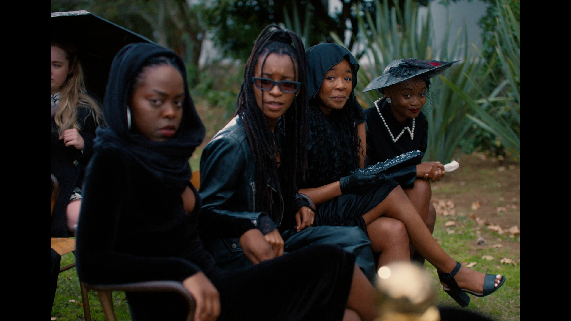 Luthando and three schoolmates sit together outdoors in a scene from Black Burns Fast.