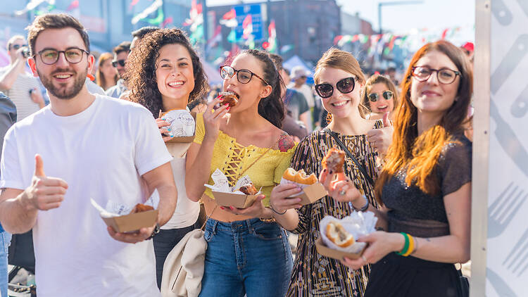 Ferragosto one man and four women eat some food at a street festival