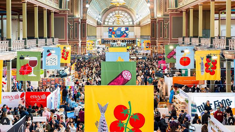 The Little Food Market stall holders, crowds and banners inside an exhibition room