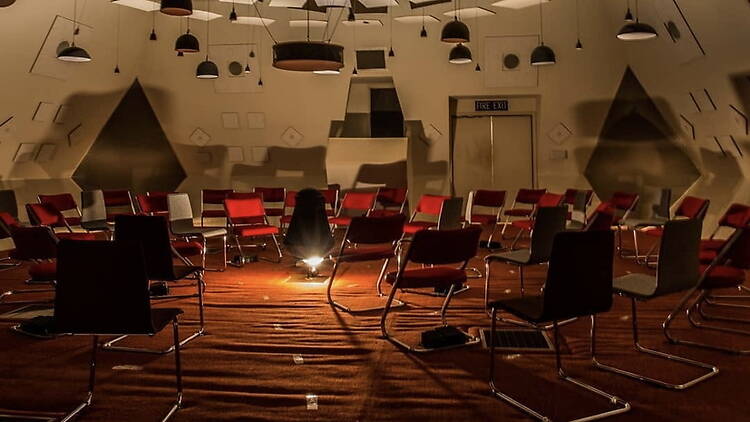 A wide shot of empty chairs arranged in a circle inside an event venue.