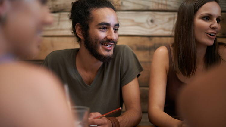 A close-up of people talking and smiling together at a table A close-up of people talking and smiling together at a table