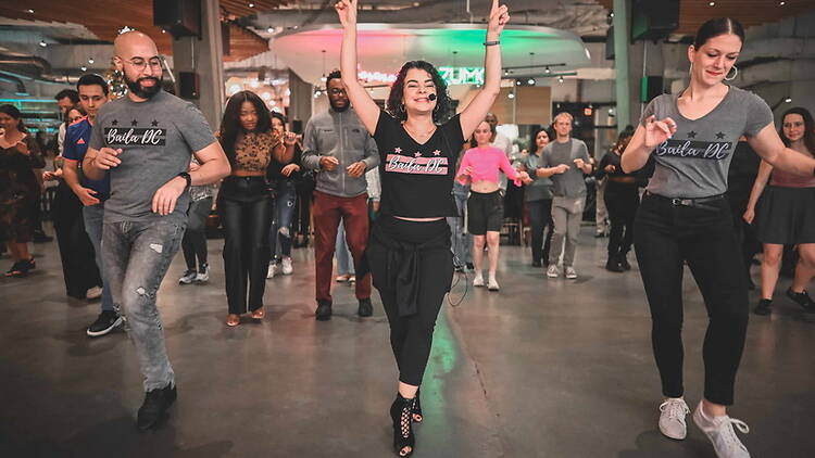 Wide shot of people dancing at an indoor dance event. Wide shot of people dancing at an indoor dance event.