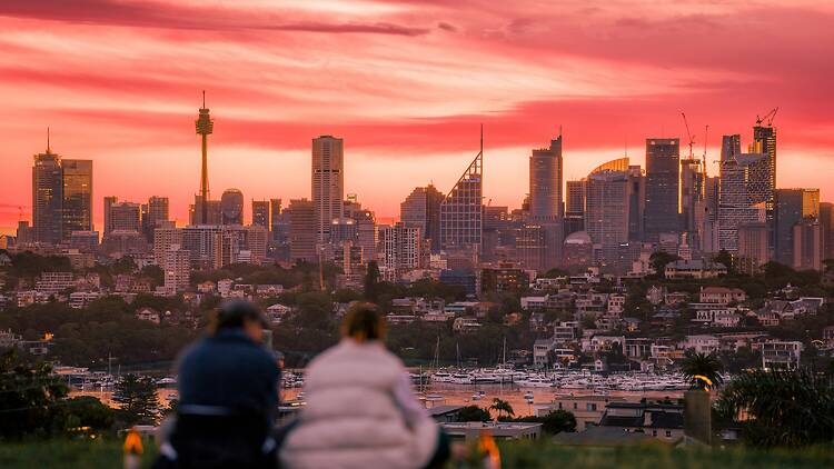 Observatory Hill A man and a woman sitting on a hill overlooking a city