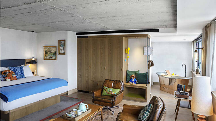 Treehouse Hotel bedroom showing a double bed, lounge area and tin bath