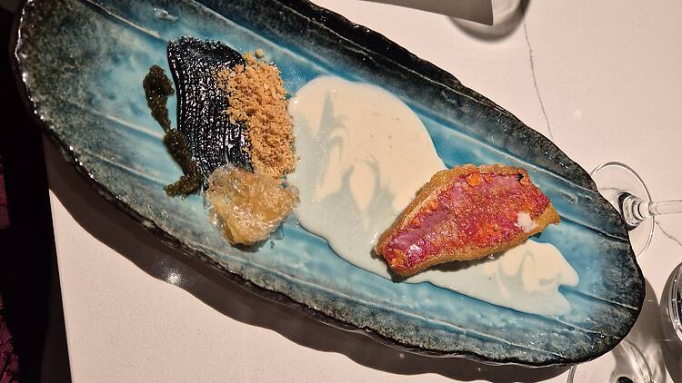 Seataphor – spirulina ocean waves, red mullet, and edible 'plastic' made with yam flour, with a squid ink oil spill