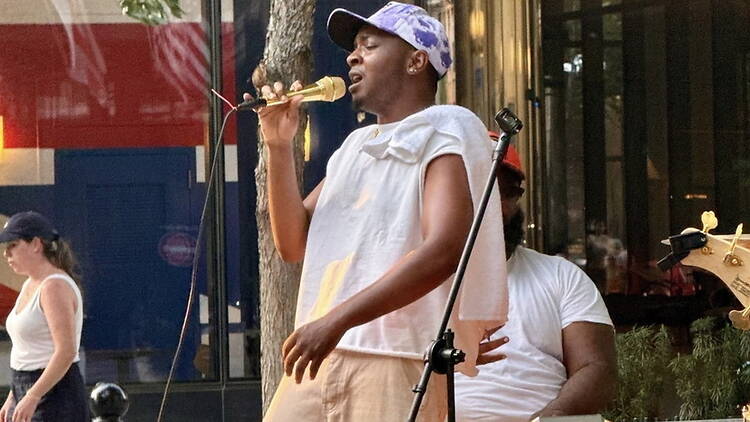 A close-up of a singer performing into a microphone outdoors. A close-up of a singer performing into a microphone outdoors.