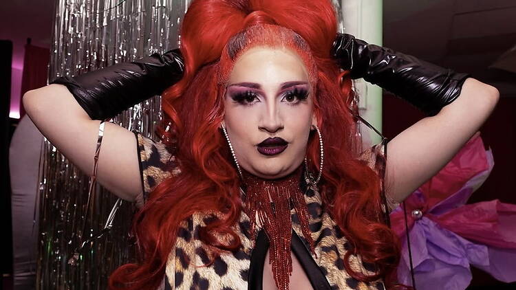 Close-up of a performer adjusting red hair accessories at an indoor event venue