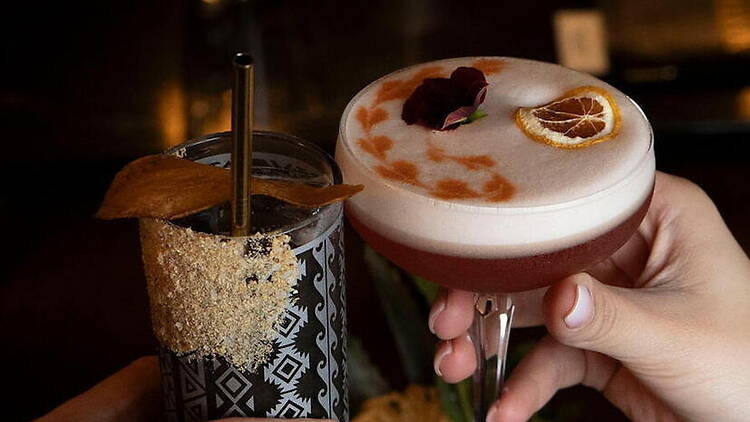 Close-up of cocktails being held together at a bar Close-up of cocktails being held together at a bar