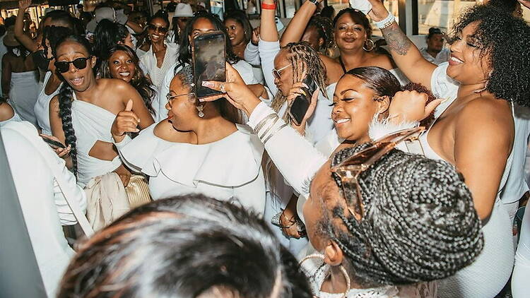 A close-up of people dancing and taking photos at an event.