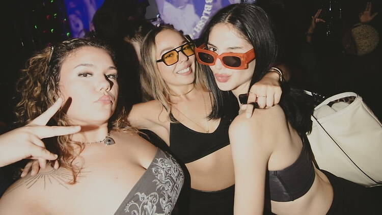 A close-up of three people posing together at an event.