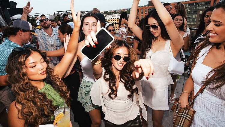 A wide shot of people dancing and celebrating at an outdoor event. A wide shot of people dancing and celebrating at an outdoor event.