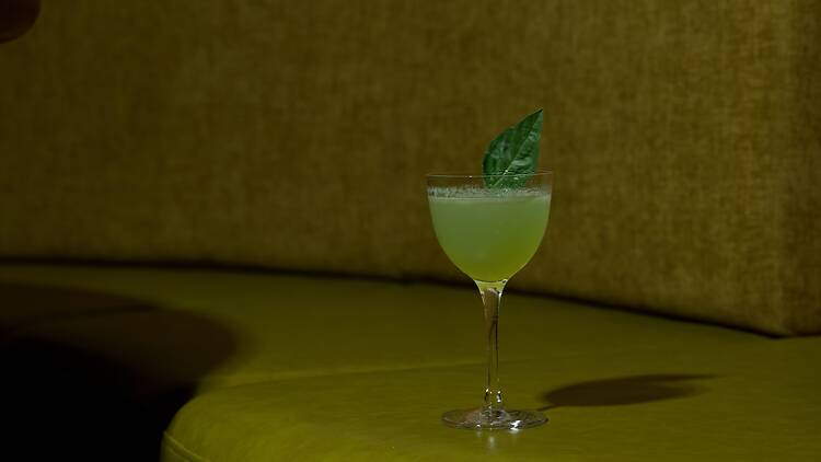 A green cocktail on a green surface.