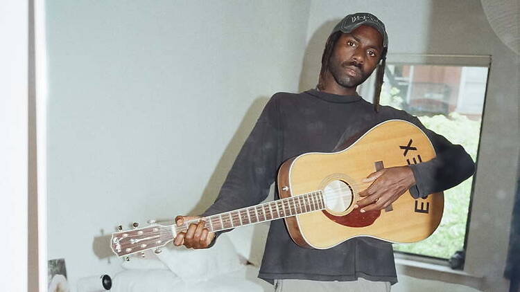 A person playing an acoustic guitar in a room