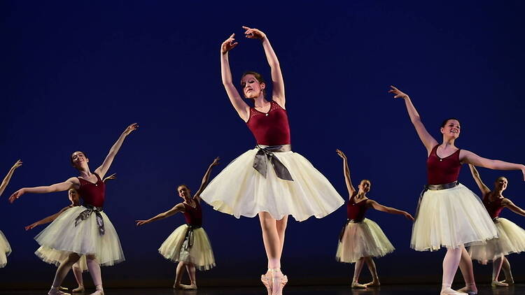 A wide shot of ballet dancers performing on stage in matching costumes
