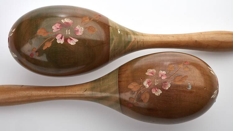 A pair of brown maracas with painted pink flower detail.
