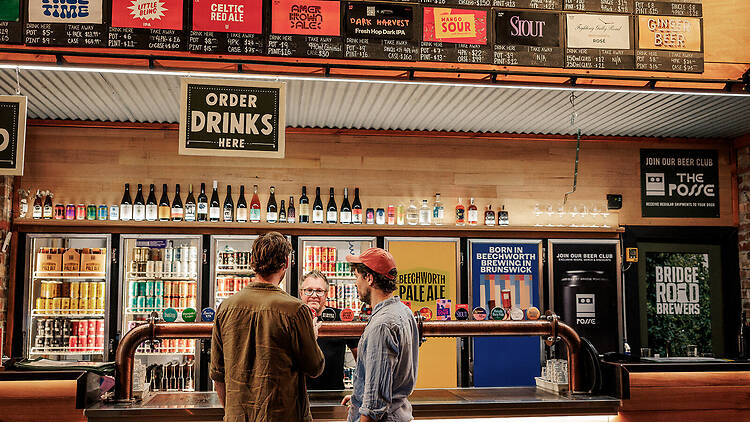 People ordering beer at the bar.