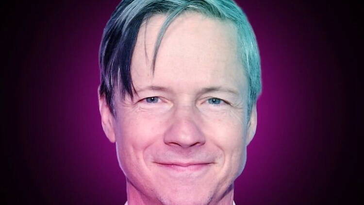 A close-up of a person smiling against a purple and blue backdrop. A close-up of a person smiling against a purple and blue backdrop.