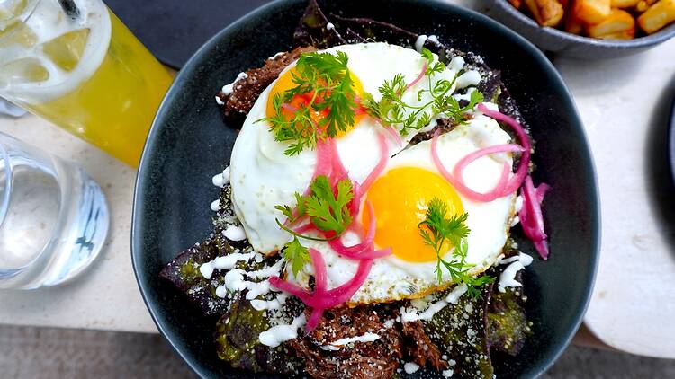 a bowl of Chilaquiles in a black bowl