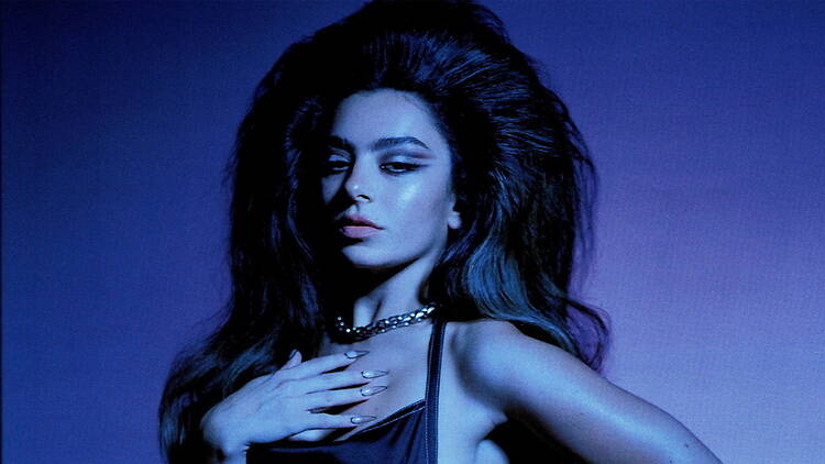 Close-up of a person posing against a blue-lit studio backdrop
