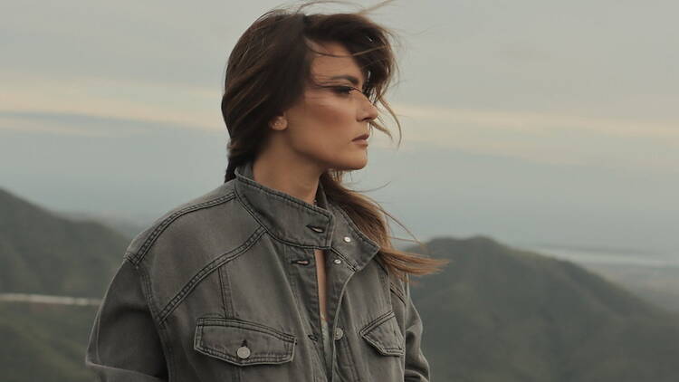 Close-up of a person standing outdoors against a mountainous landscape Close-up of a person standing outdoors against a mountainous landscape
