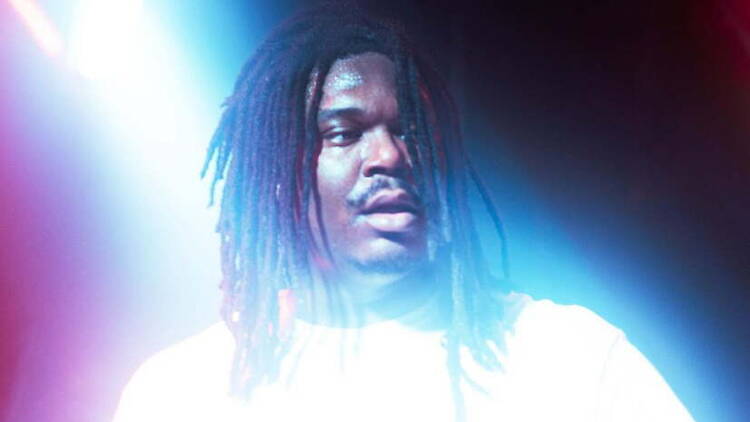 Close-up of a performer standing under colorful stage lights at a live music venue Close-up of a performer standing under colorful stage lights at a live music venue