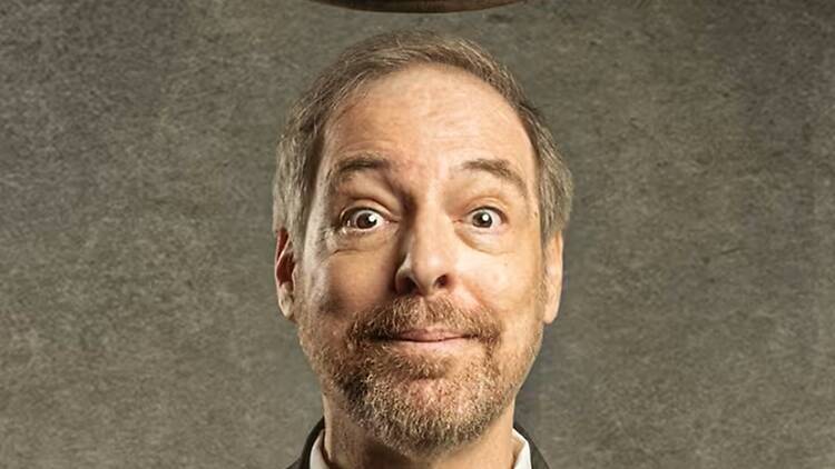 A close-up of a person posing with a surprised expression against a gray backdrop. A close-up of a person posing with a surprised expression against a gray backdrop.