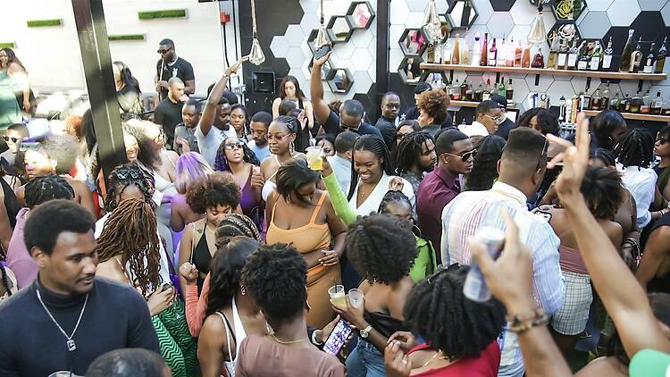 A wide shot of a crowd dancing and socializing at an indoor event. A wide shot of a crowd dancing and socializing at an indoor event.