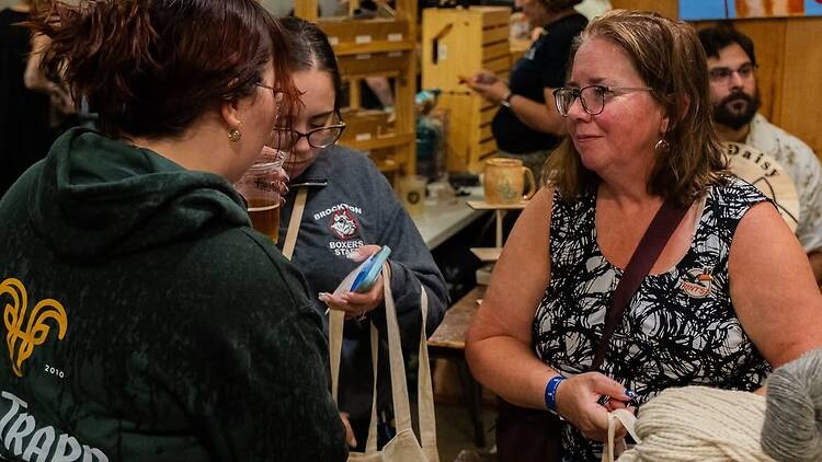 Candid photo of attendees chatting and socializing at an indoor event. Candid photo of attendees chatting and socializing at an indoor event.
