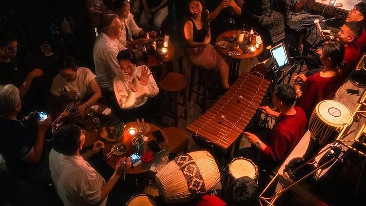 People gathered around a live band in Tep Bar, Bangkok People gathered around a live band in Tep Bar, Bangkok