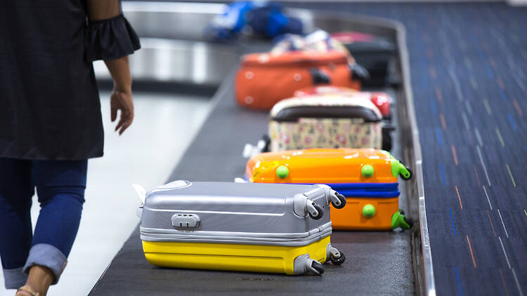 Suitcases on an airport luggage belt Suitcases on an airport luggage belt