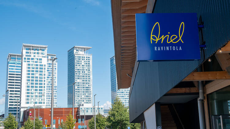 Ravintola Arielin kyltti taustallaan Kalasataman tornitalot