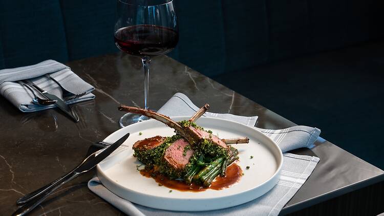 two lamb lollipops on a plate